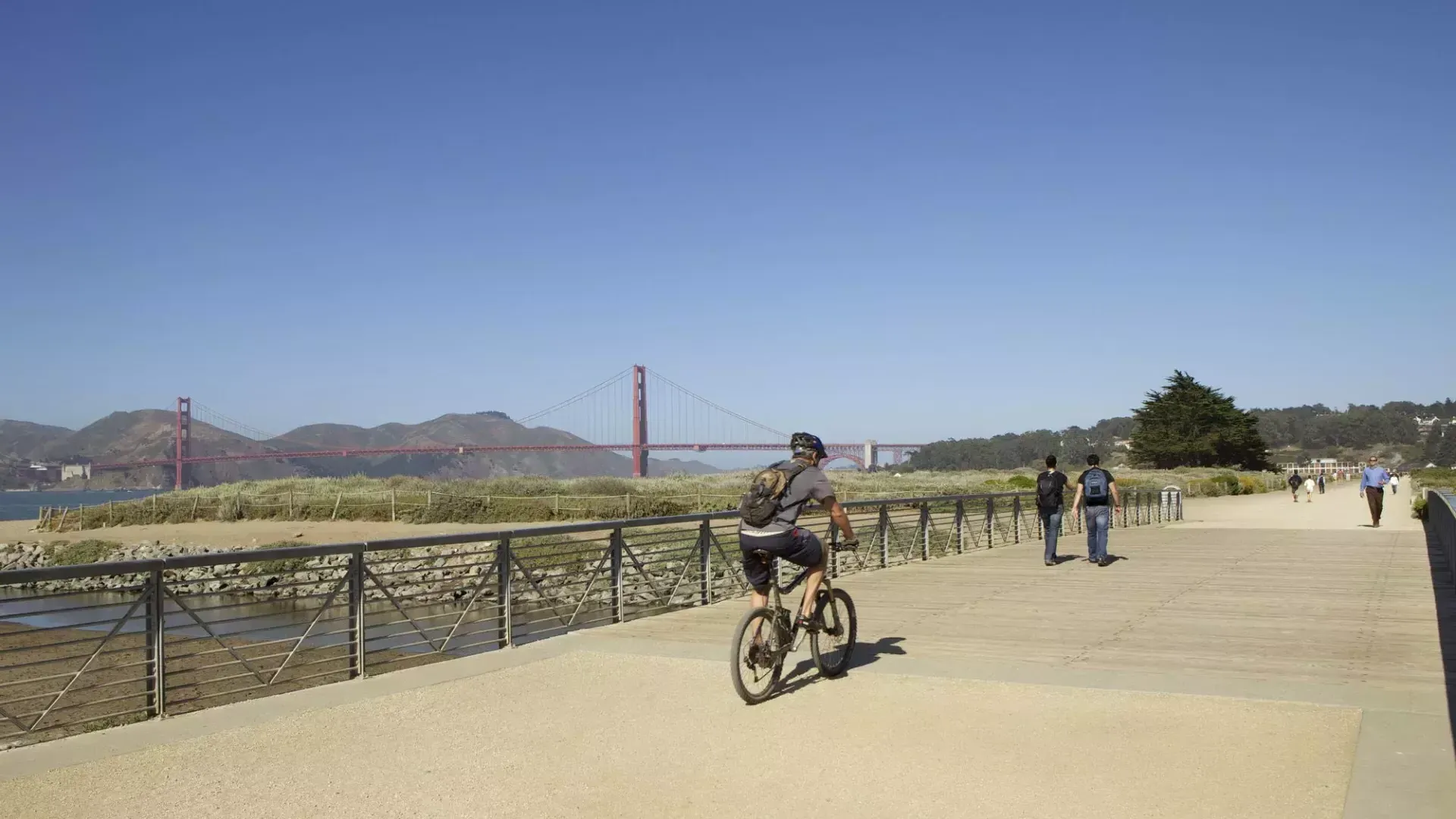 Un hombre anda 自行车 por un sendero en Crissy Field. 加州贝博体彩app.