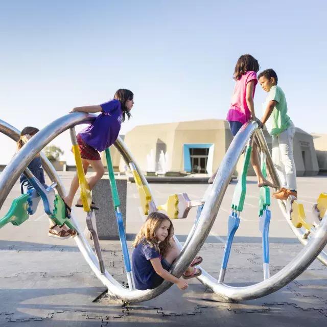 Kinder spielen auf einem Spielplatz.